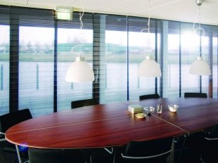 Panel glide system with pleated film panels for stylish sun protection in conference rooms