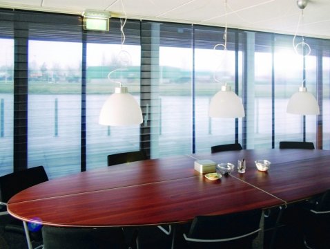 Panel glide system with Multiwave pleated panels for stylish sun protection in conference rooms